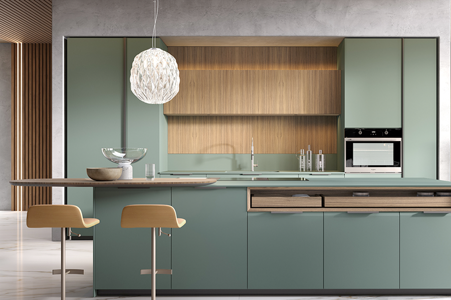 Cucina con mobili verde salvia e penisola in legno progettata da Regina Design