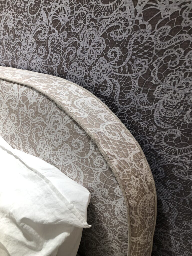 Testata letto e parete rivestite con la stessa texture effetto pizzo