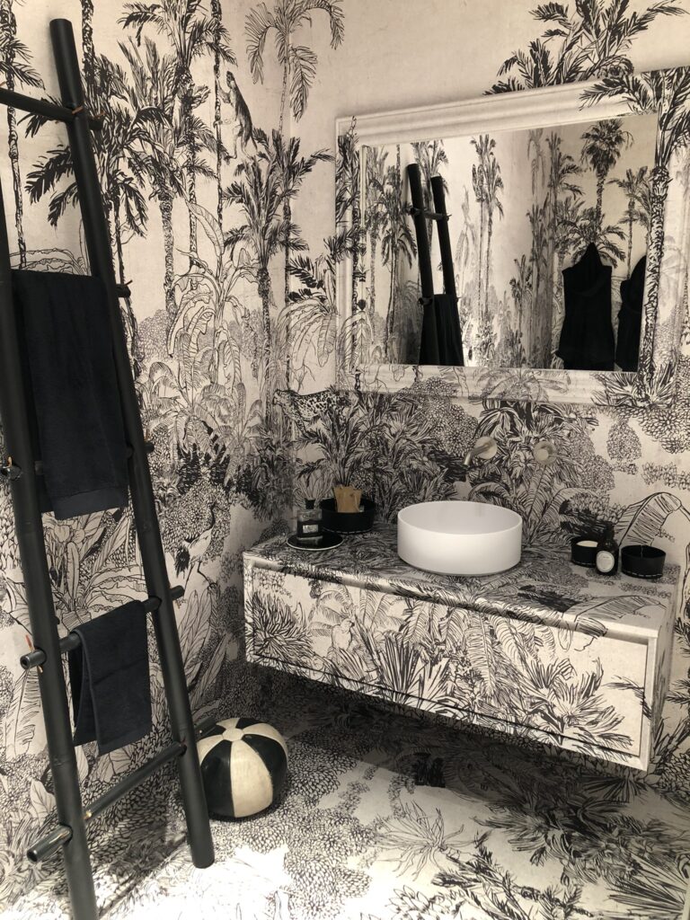 Bagno con rivestimento continuo a tema tropicale
