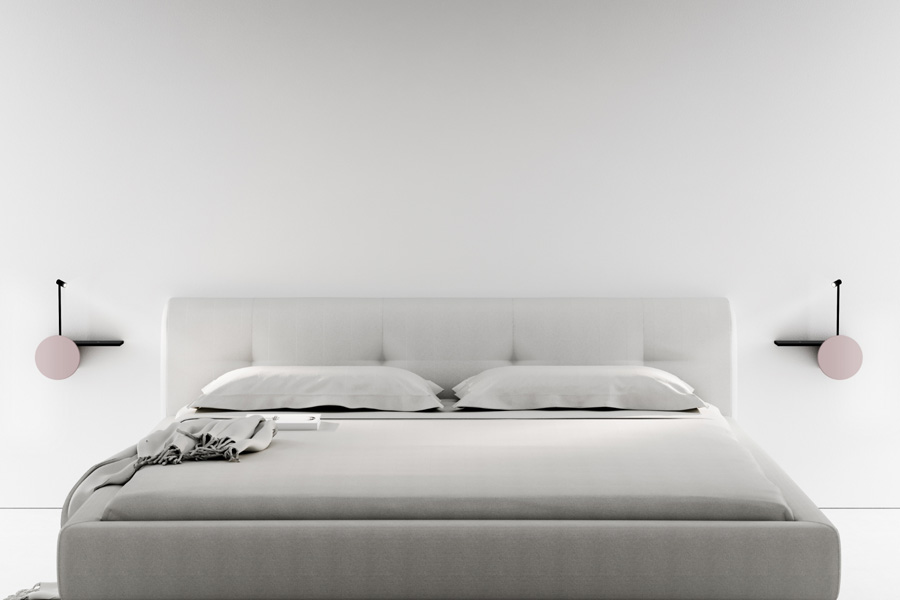 Due lampade Biga nere con frontalino rosa installate ai lati di un letto matrimoniale bianco