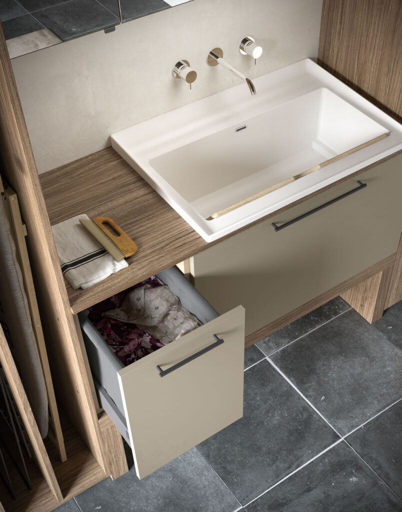 Lavatoio bianco con cassetto estraibile contenente biancheria