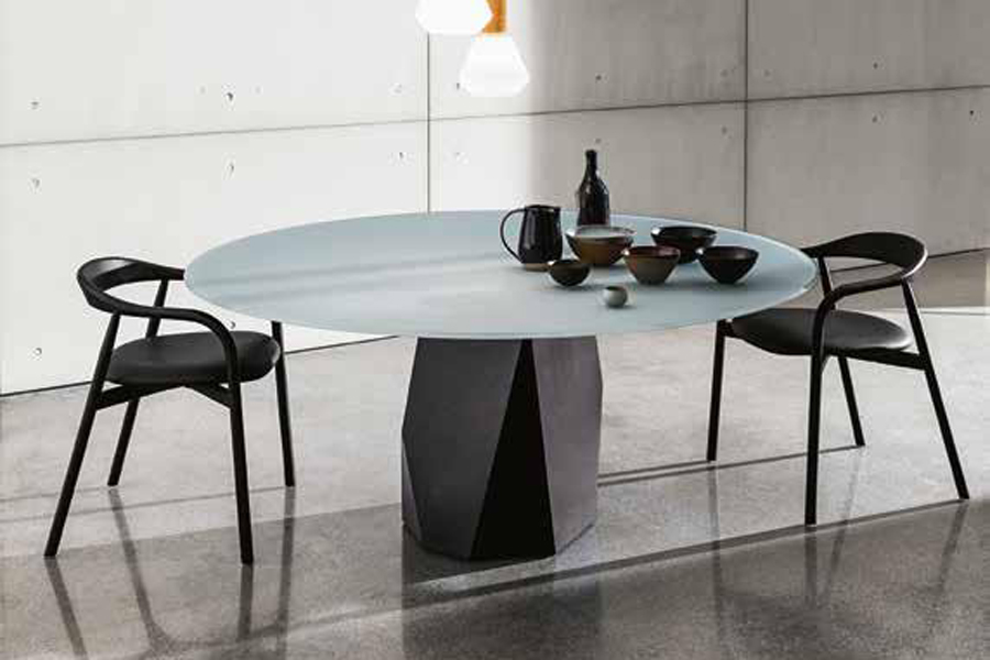 Tavolo rotondo con piano in vetro azzurro e sedute in legno curvato