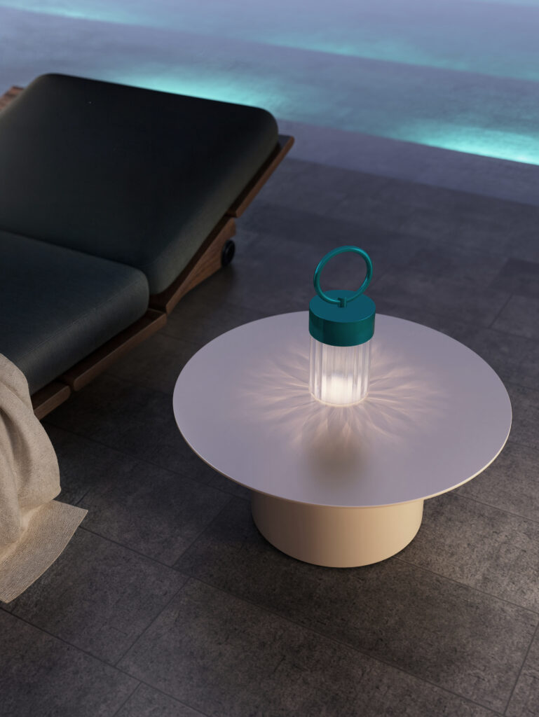 Lampada Claretta turchese accesa accanto a chaise longue vicino alla piscina
