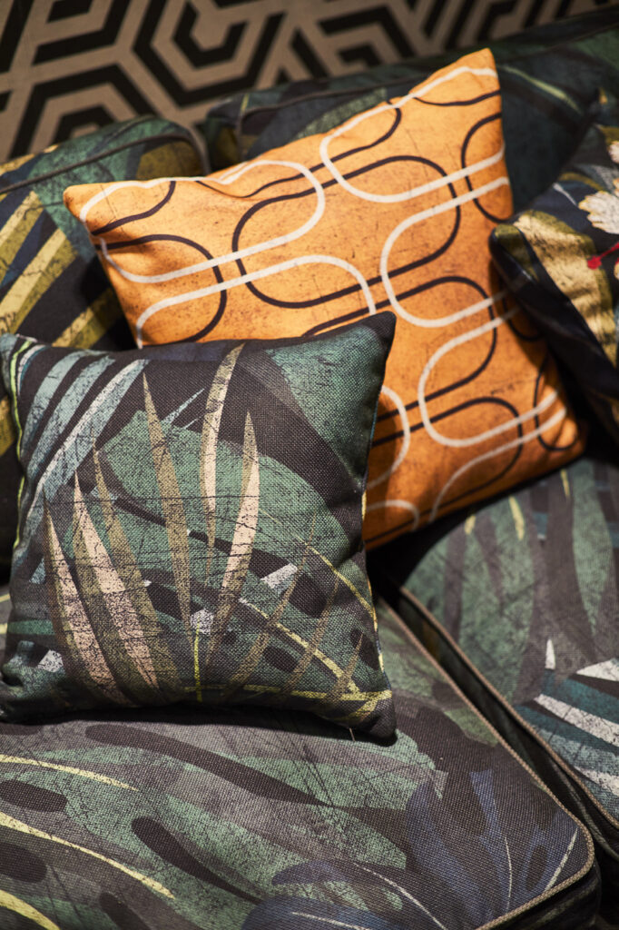 Cuscini Momenti con pattern tropicale e geometrico su divano modulare