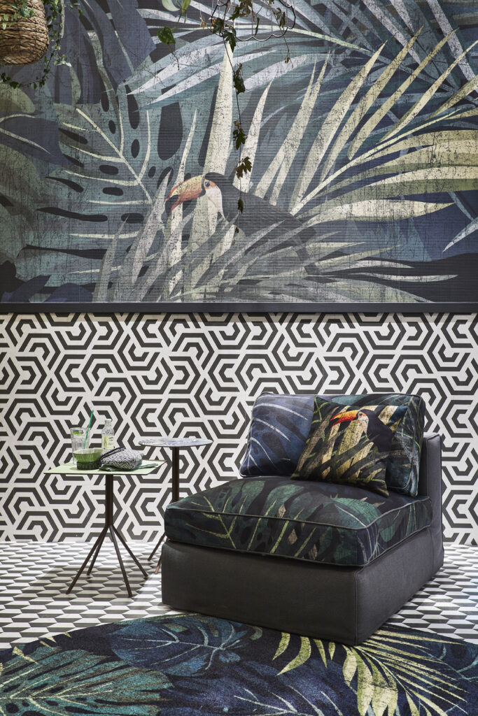 Poltrona modulare Momenti con cuscino tropicale e due tavolini con piano stampati.