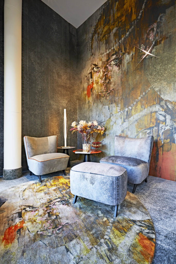 Spazio arredato con tappeto e rivestimento murale con grafica di Marco Grassi